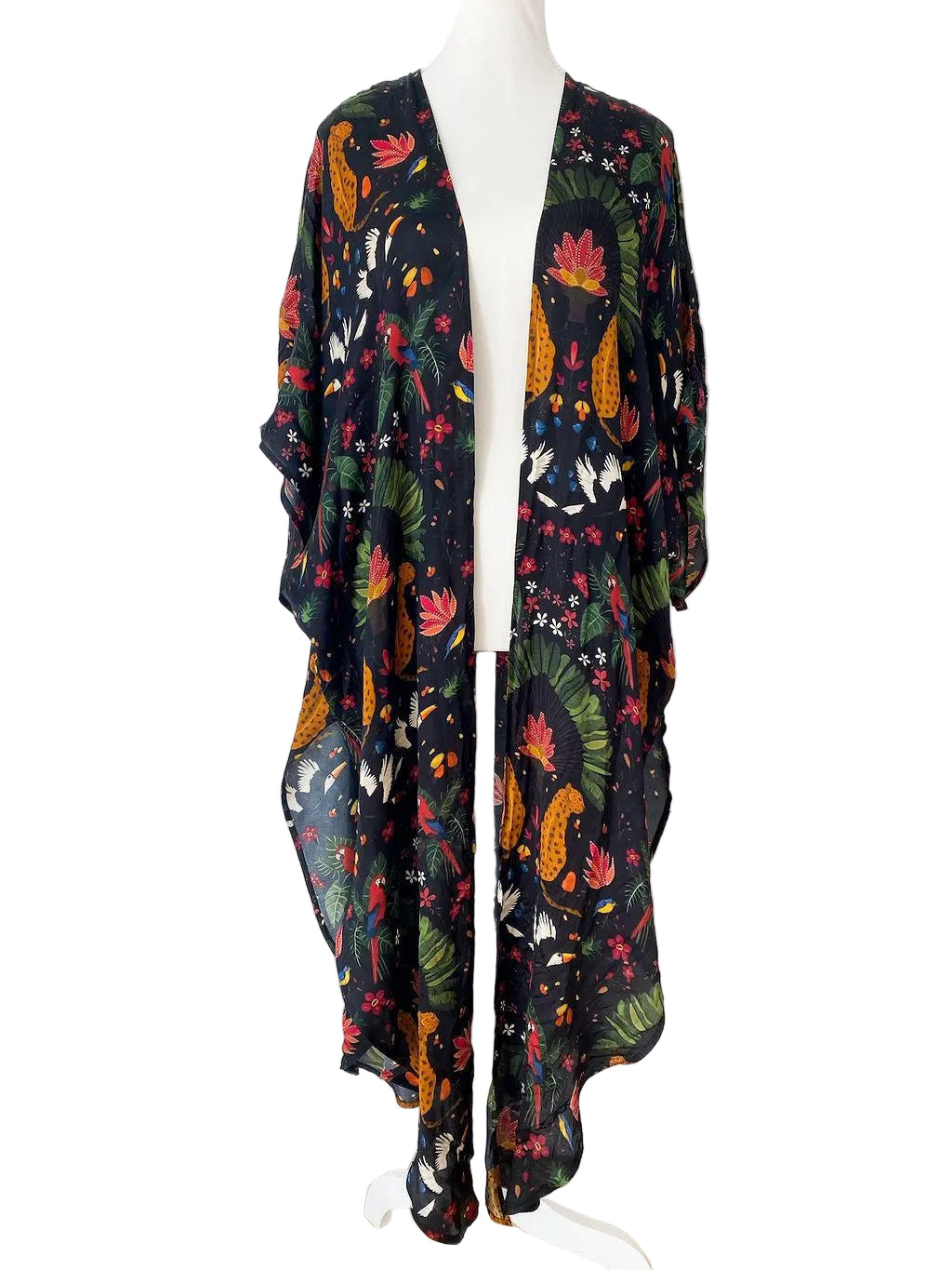 Colorful floral-patterned kimono on a mannequin against a white brick wall.