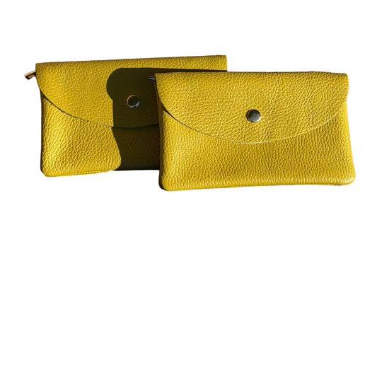 Two chartreuse leather pouches on a wooden surface. They are called cell phone wallets.
