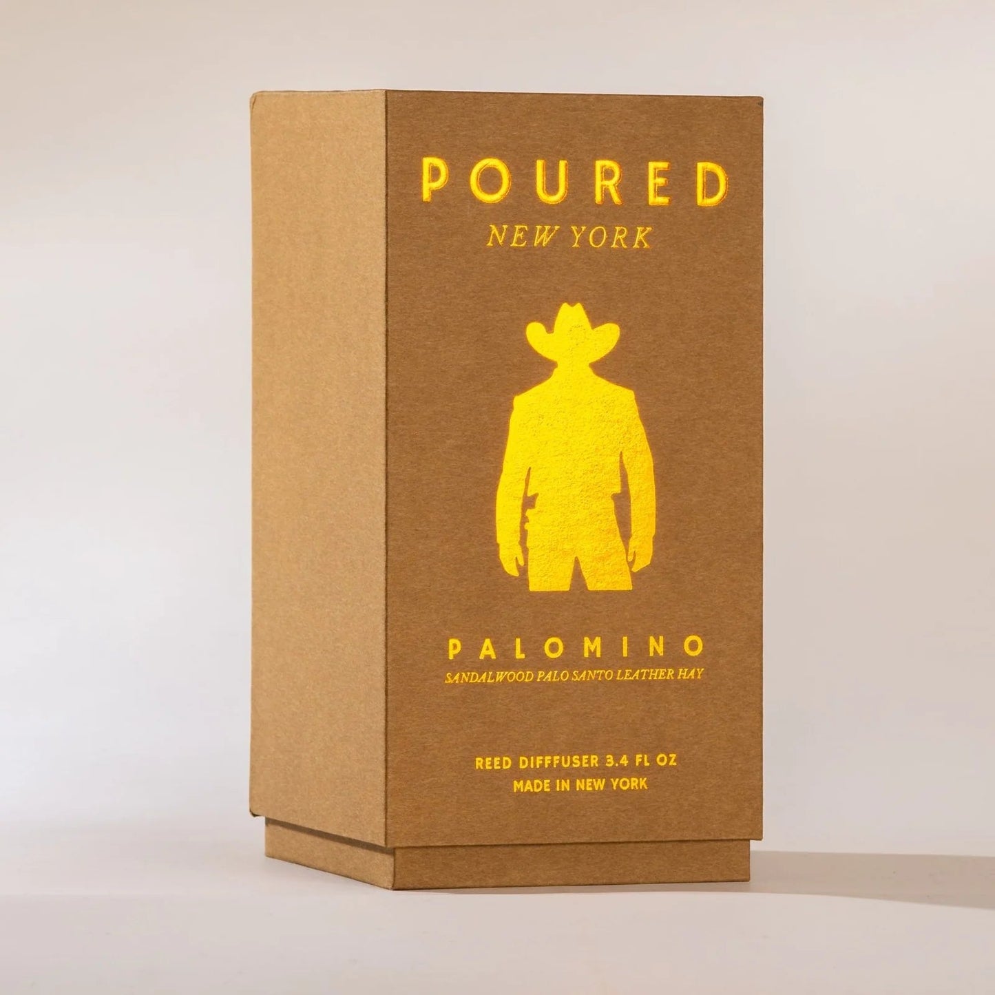 Brown box with yellow text and silhouette of a person wearing a cowboy hat on a beige background