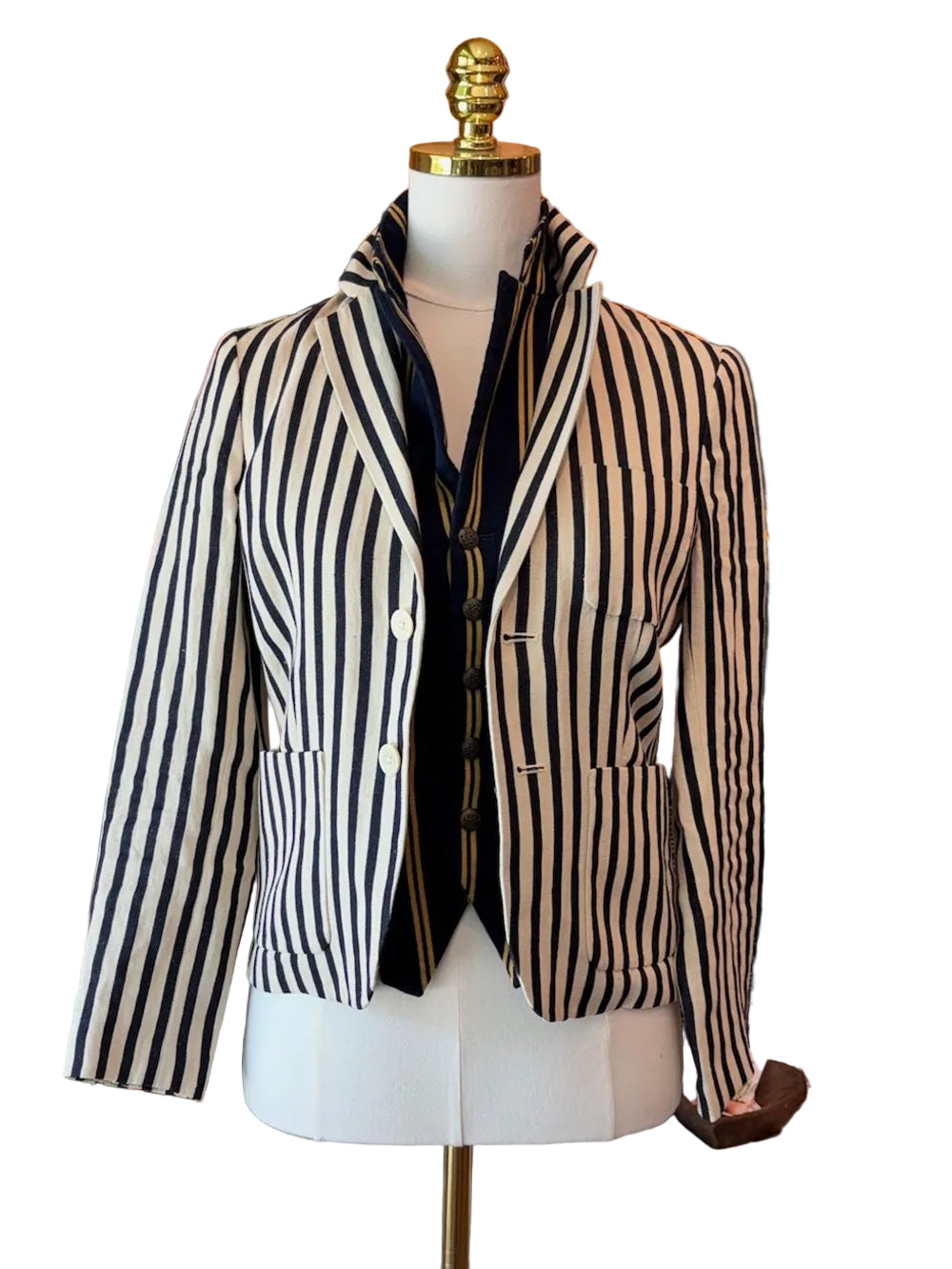 A black and cream vertical striped linen blazer jacket displayed on a white mannequin torso, styled with a black shirt underneath, set against a white background
